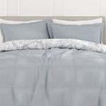 Modern grey bedspread with pillows on bed