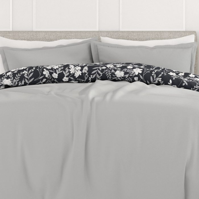 Bed with gray sheets and floral pillow