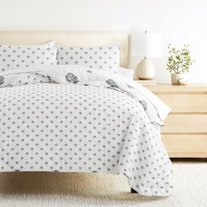 Stylish bedding set with geometric patterns on bed.